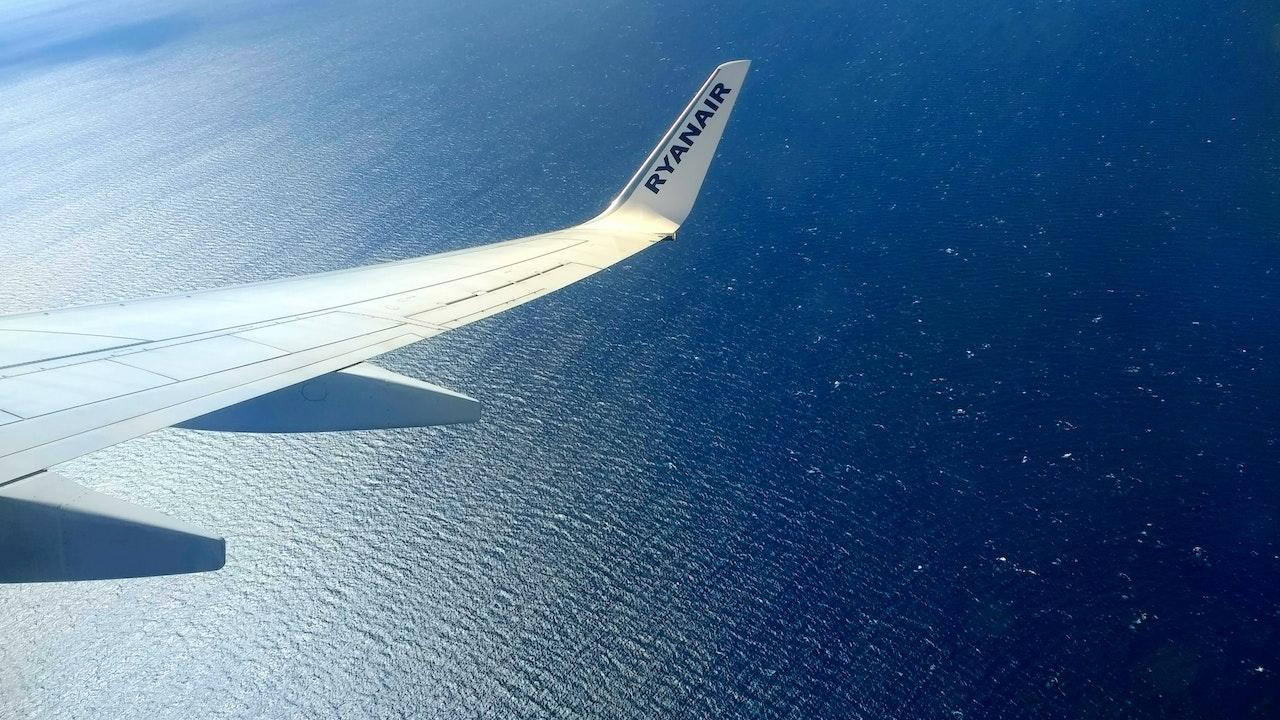 Ein Flugzeug des Billigfluganbieters Ryanair fliegt über einem Meer oder Ozean. 