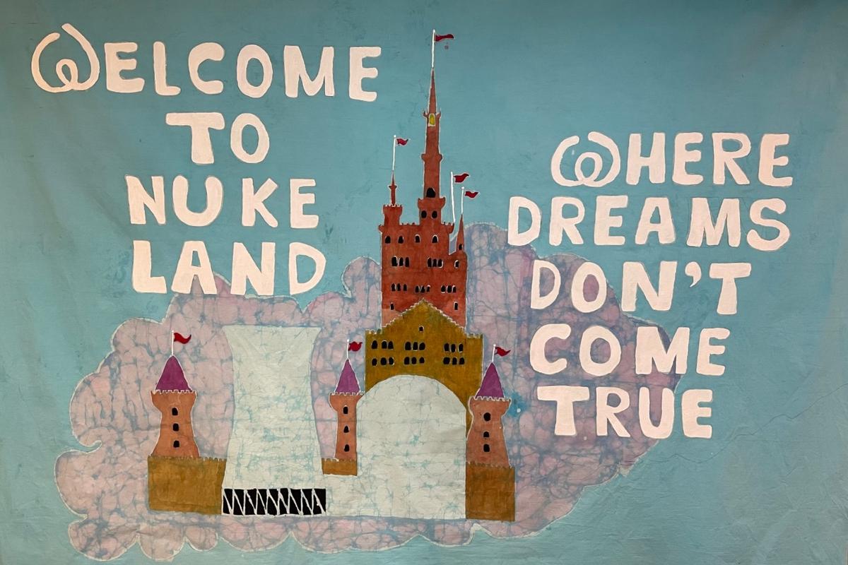 Grafik Atomkraftwerk in städtischer Umgebung, Aufschrift "Welcome to nuke land were dreams don´t come true"