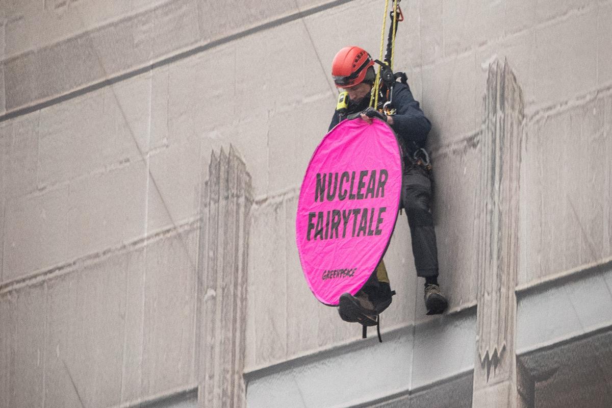 Ein Greenpeace-Aktivist seilt sich über den Pressebereich des Atomgipfels ab