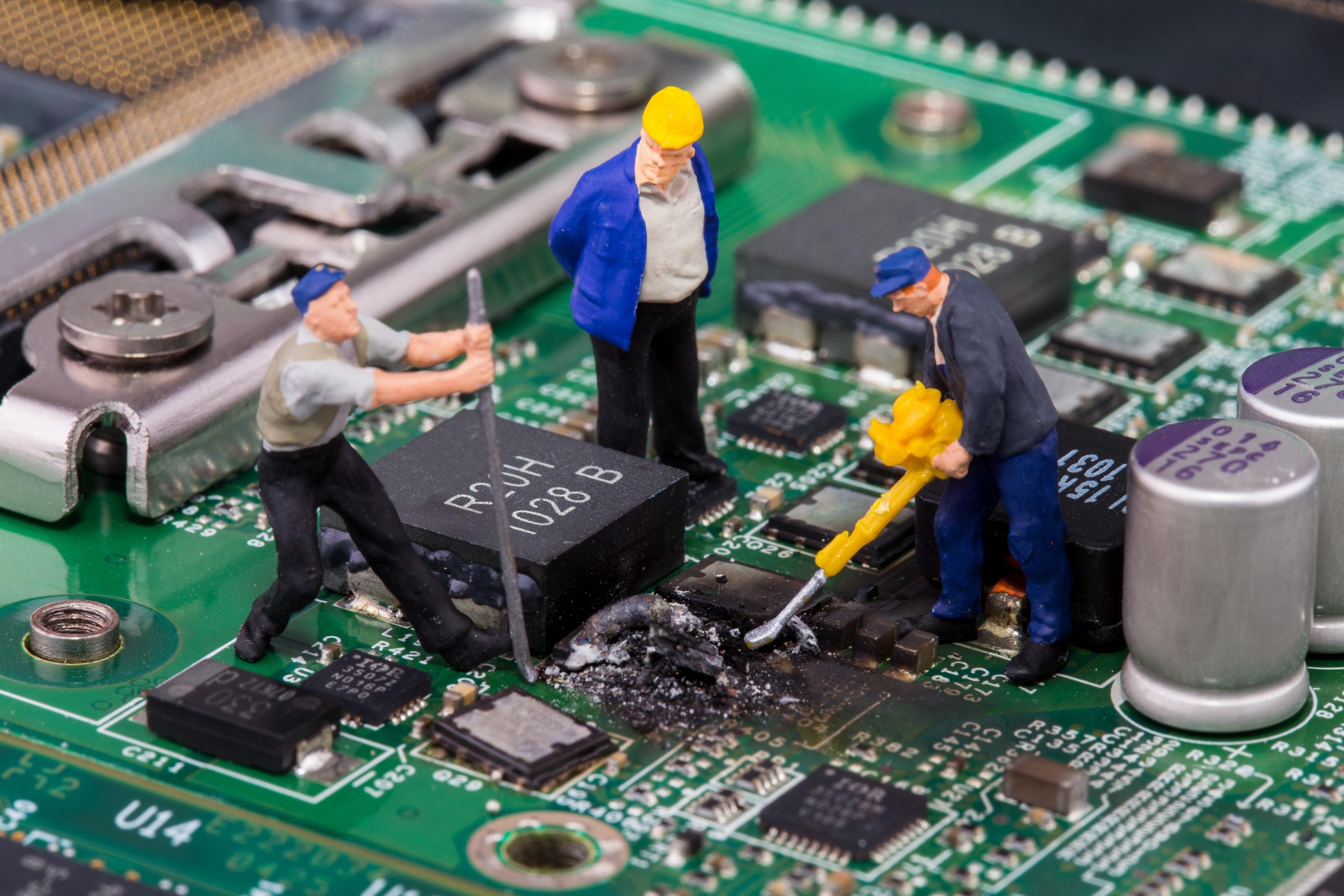 Miniaturarbeiterfiguren reparieren defektes Mainboard vom Computer